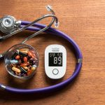 hemoglobina glikowana, glukometr na stole, tabletki w miseczce